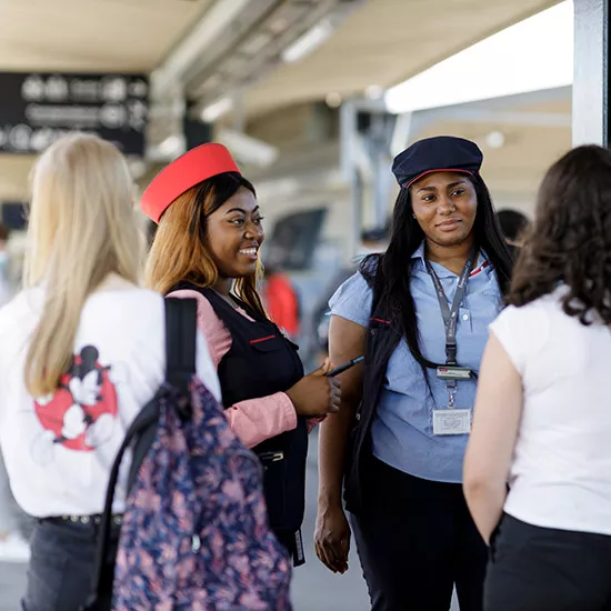 Agentes avec voyageuses en gare