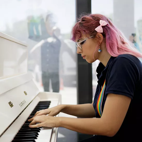 Femme jouant sur un piano en gare