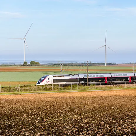 TGV INOUI en campagne devant des éoliennes