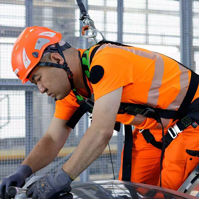 Agent de maintenance avec un harnais de sécurité