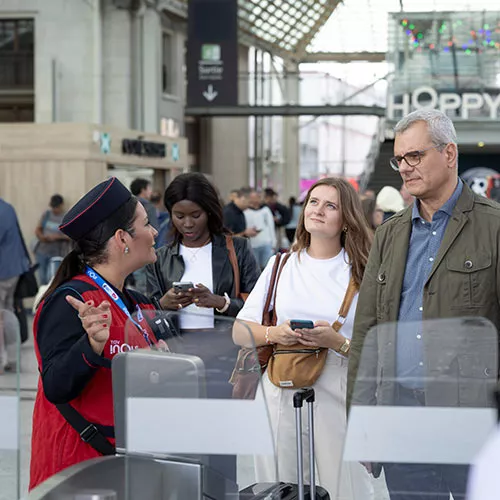 Agent d'escale renseignant des voyageurs à l'embarquement